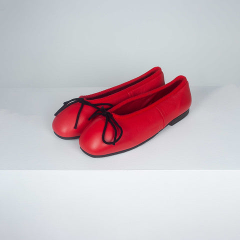 Comme des Garçons red leather ballet shoes with hard toe, black decorative bow and black slightly heeled soles.