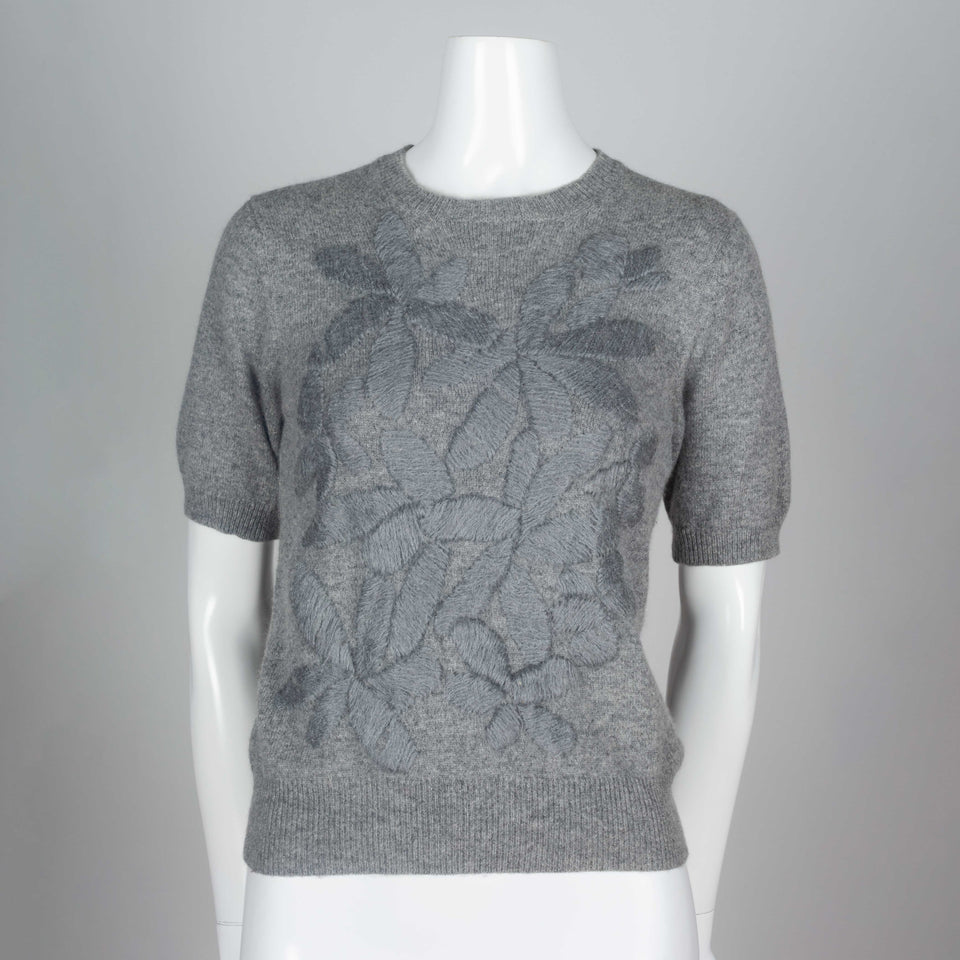 Comme des Garçons, a gray short sleeve sweater with silk embroidered flowers on front. 