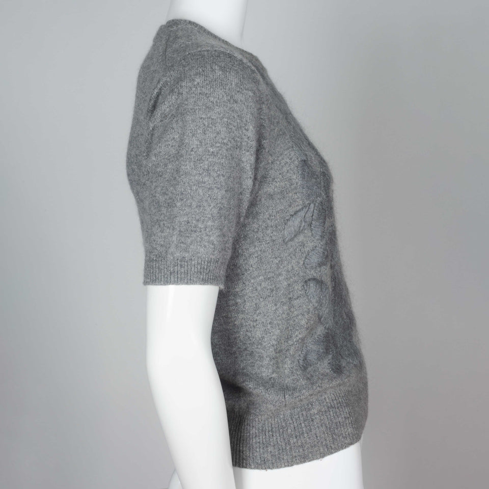 Comme des Garçons, a gray short sleeve sweater with silk embroidered flowers on front. 