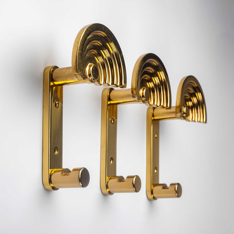 Architectural coat hooks in polished brass by Ettore Sottsass. 